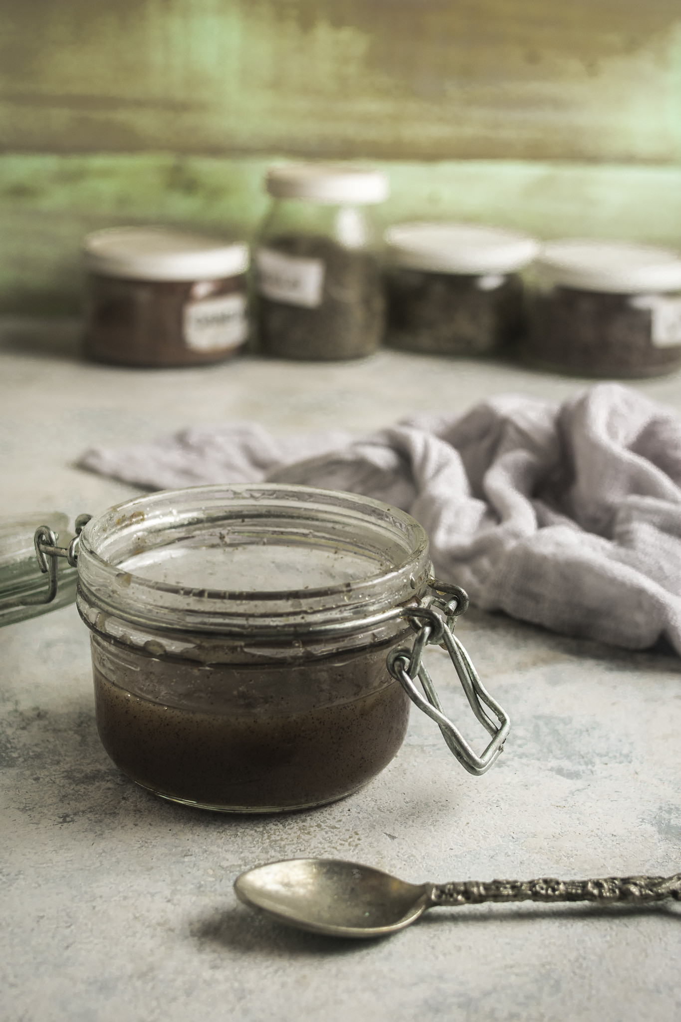 Jar of homemade vanilla bean paste with a spoon.
